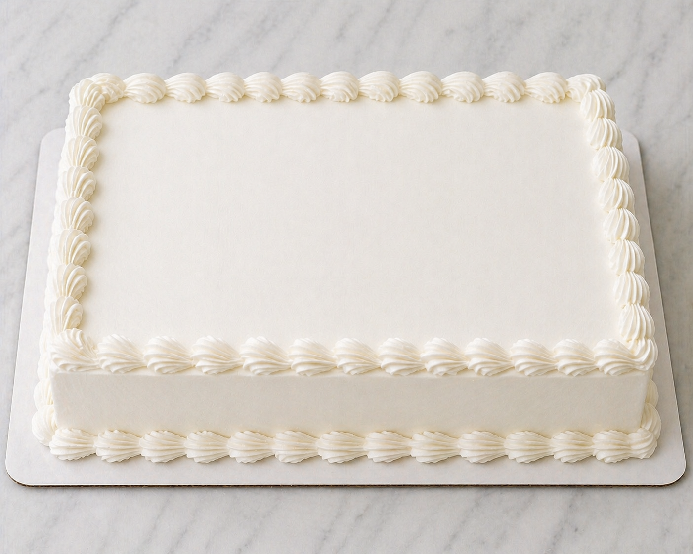 Rectangular cake with white frosting on a marble surface